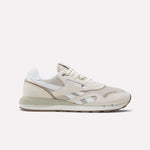 The Reebok Classic Nylon 89 Shoes feature beige and white suede and mesh panels, cushioned midsole, retro design, white laces, Reebok branding, and a low-profile rubber sole shown against a plain background.