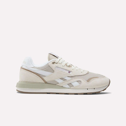 The Reebok Classic Nylon 89 Shoes feature beige and white suede and mesh panels, cushioned midsole, retro design, white laces, Reebok branding, and a low-profile rubber sole shown against a plain background.
