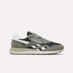 The Reebok Classic Nylon 89 Shoes are displayed in side profile, featuring gray, black, and white suede and mesh panels with white logo stripes and a beige rubber sole, set against a plain light background.
