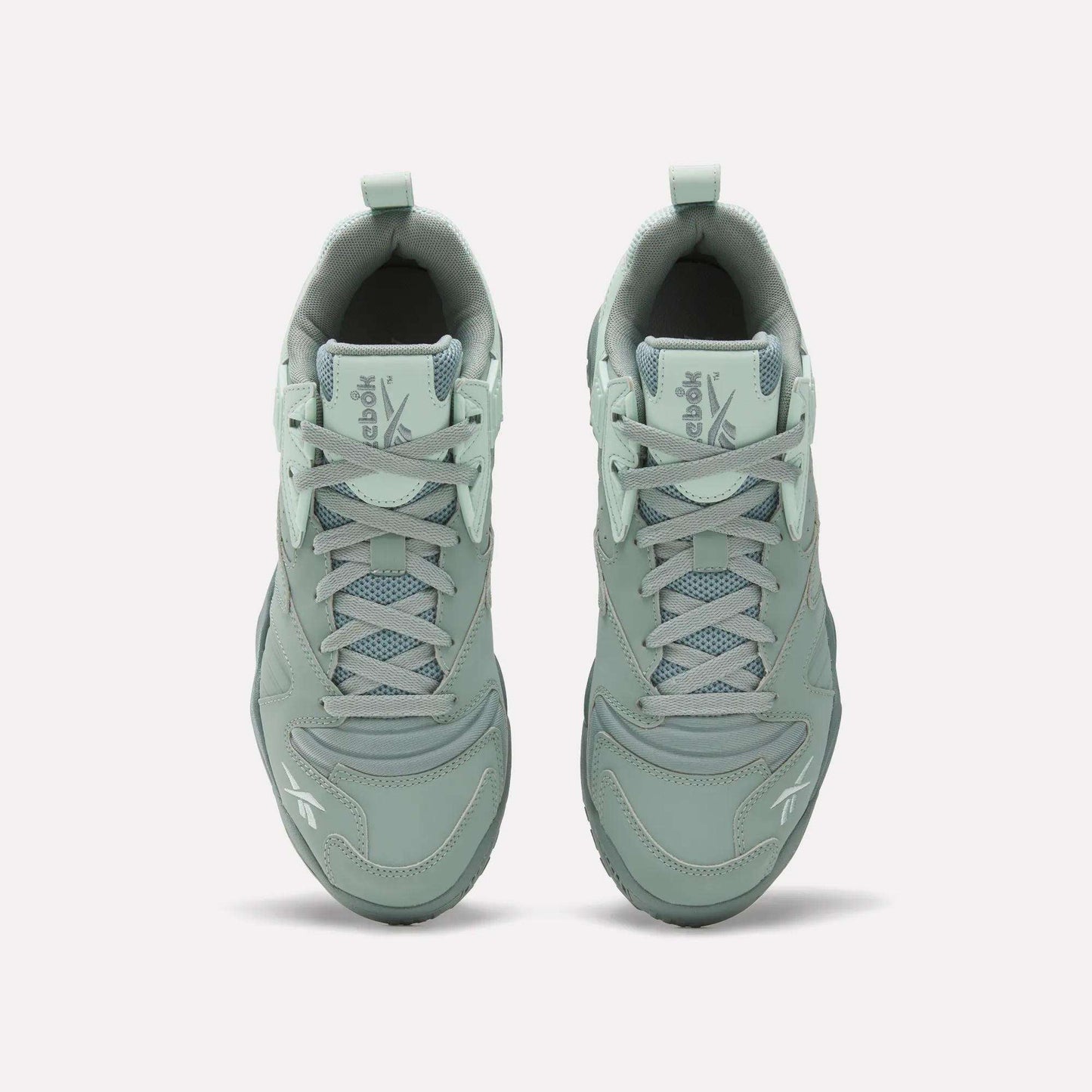 Top view of Reebok Brutus Low Shoes in light green with laces, mesh detailing, and Reebok logos on the tongue and toe. Features an EVA midsole for comfort, shown on a plain white background.