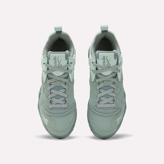 Top view of Reebok Brutus Low Shoes in light green with laces, mesh detailing, and Reebok logos on the tongue and toe. Features an EVA midsole for comfort, shown on a plain white background.