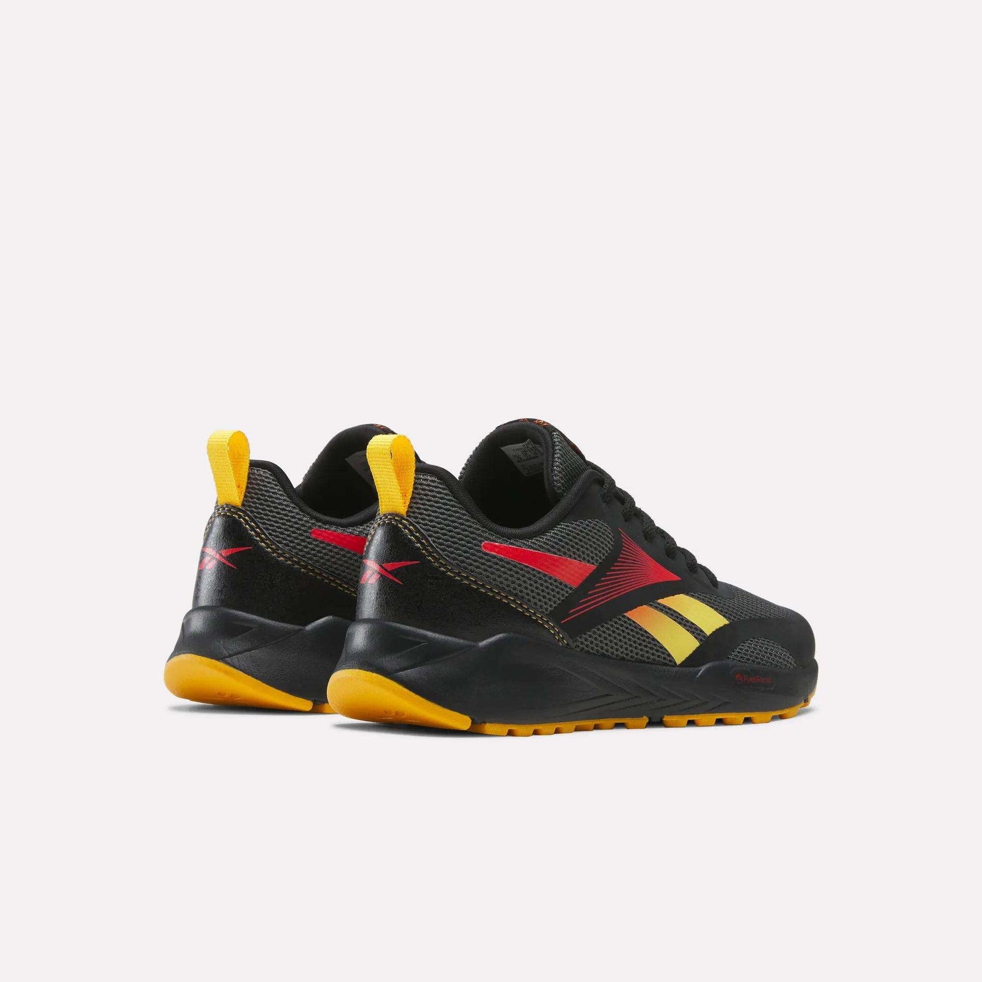 A pair of Reebok Energen Running Shoes for little kids in black with yellow and red accents, featuring yellow heel tabs and orange soles. These athletic shoes offer a cushioned midsole for extra comfort and are displayed at an angle to showcase the sides and backs against a plain white background.
