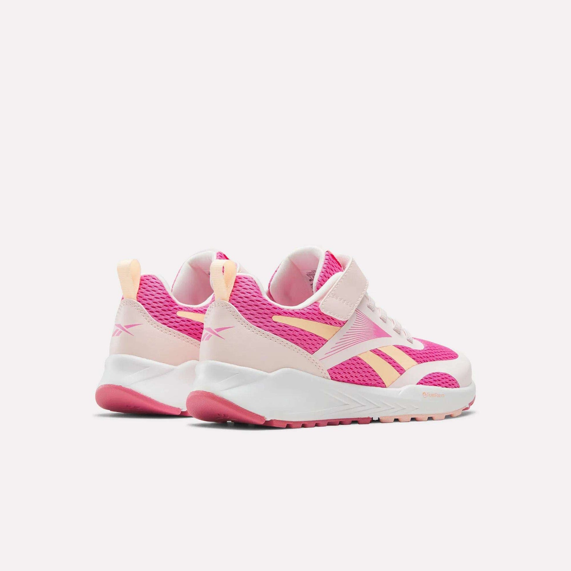Pair of Reebok Energen Running Shoes for little kids in pink and white, featuring breathable mesh uppers, Velcro straps, yellow accents, and light pink soles, all displayed against a plain white background.
