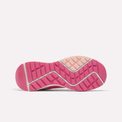 The image displays the pink sole of the Reebok Energen Running Shoes - Little Kids, featuring textured patterns and grooves for traction. The design includes diagonal lines and raised rectangles with a small section in light pink near the heel. Designed for active kids, these running shoes often have mesh uppers to keep them lightweight and breathable, ensuring all-day comfort.