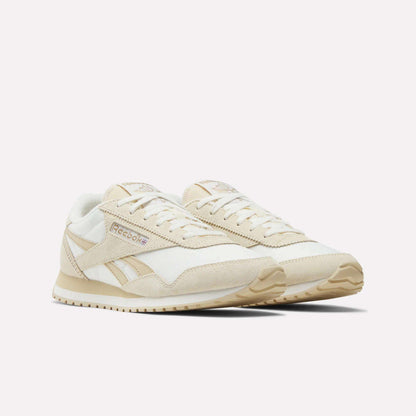 Reebok Women's Classic AZ Shoes in beige and white are shown on a plain white background, featuring a retro low-profile design with suede and mesh panels, beige soles, and Reebok branding on the side.