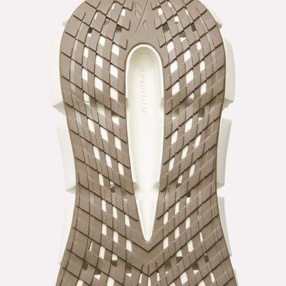 Close-up of the beige and white sole on Reebok Men's FloatZig 2 Running Shoes, showcasing a geometric crisscross tread with 'SUPERFLOW' embossed in the center, highlighting Superfloat+ cushioning for enhanced comfort.