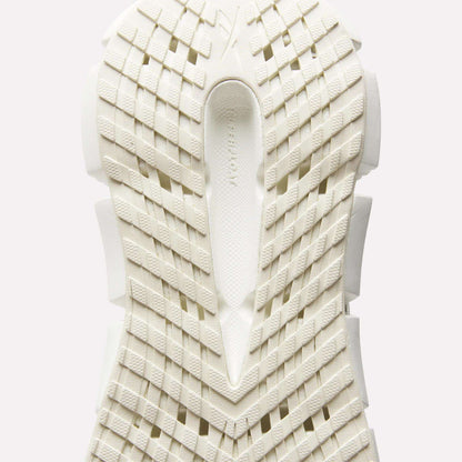 Close-up of the sole of Reebok Women's FloatZig 2 Running Shoes, featuring a white geometric grid tread and textured surface viewed from below, with subtle branding in the center to highlight its energy-returning cushioning.