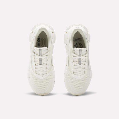 A pair of women's Reebok FloatZig 2 running shoes in white, seen from above, showcase mesh uppers, laces, and subtle Reebok branding on the insoles and tongue, with energy-returning cushioning against a plain light background.