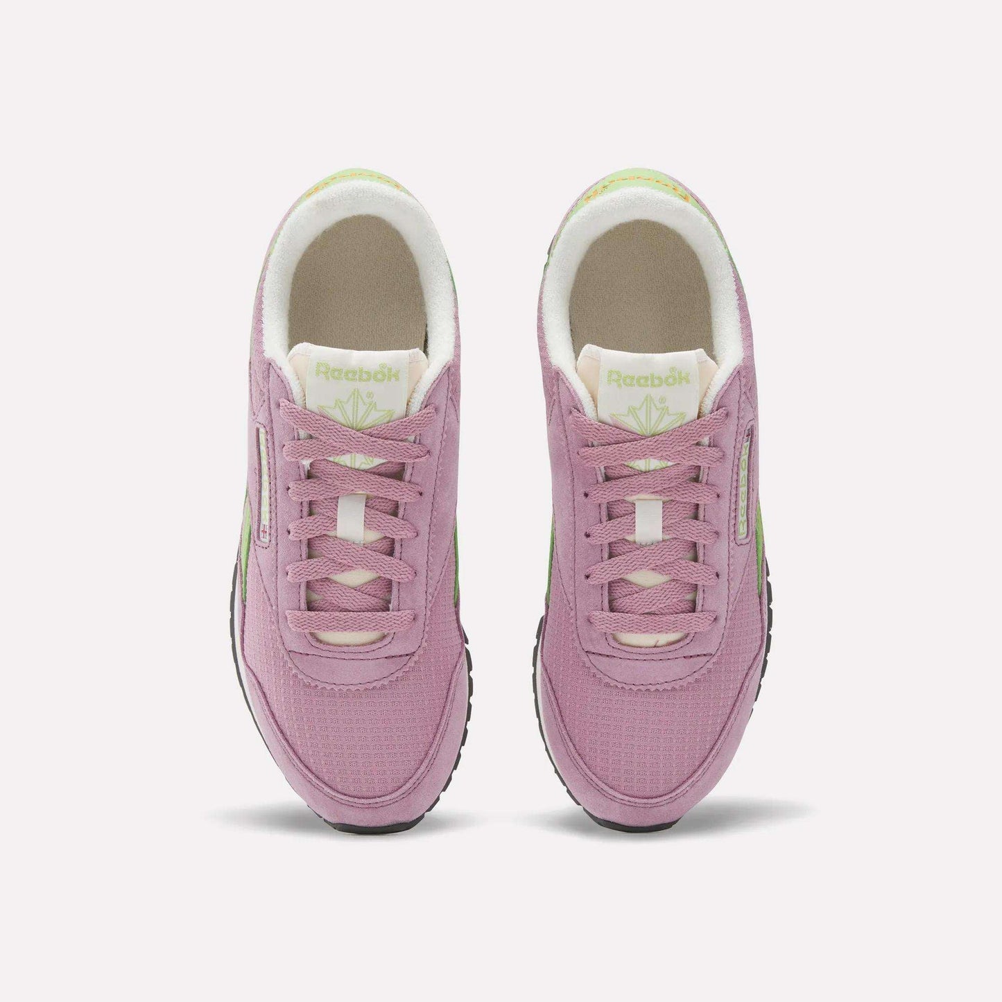 The Reebok Women's Classic AZ Shoes in pink with white soles and light green accents are shown from above on a white background, blending retro running style with a modern twist.