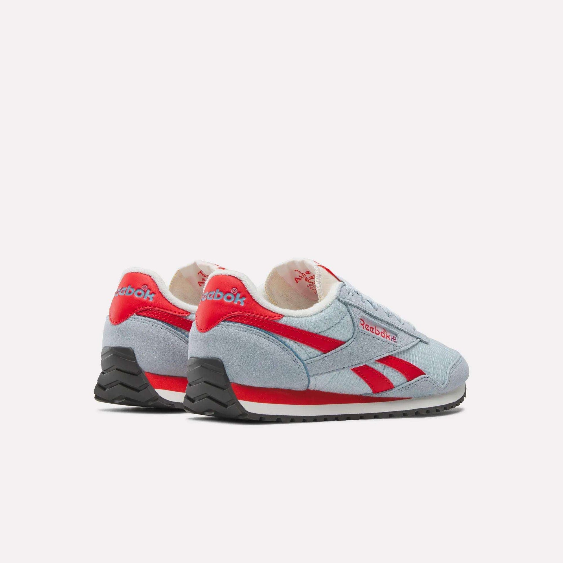 A pair of Women's Classic AZ Shoes by Reebok in light blue with red accents and black soles, set at an angle on a white background, highlight a retro running style.