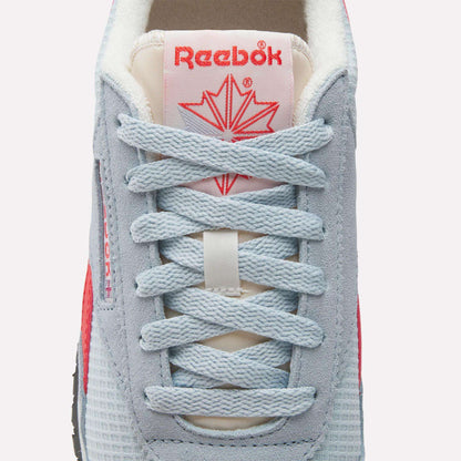 Close-up of Reebok Women's Classic AZ Shoes sneaker with light blue laces, grey and blue mesh, a red star logo on the tongue, and a hint of red on the sides—combining retro running style with modern comfort.