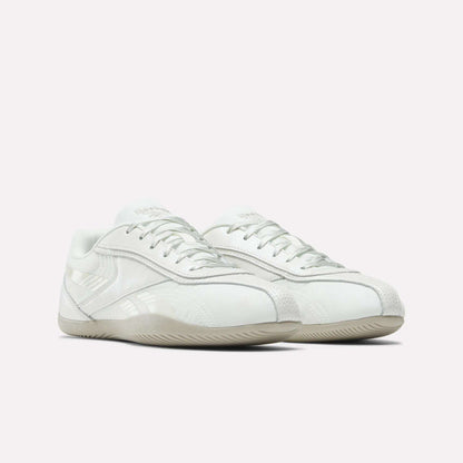 The Reebok Women's Ultra Lo Shoes feature a white low-profile design with subtle light grey accents, textured details, and off-white rubber soles, shown against a plain light background.