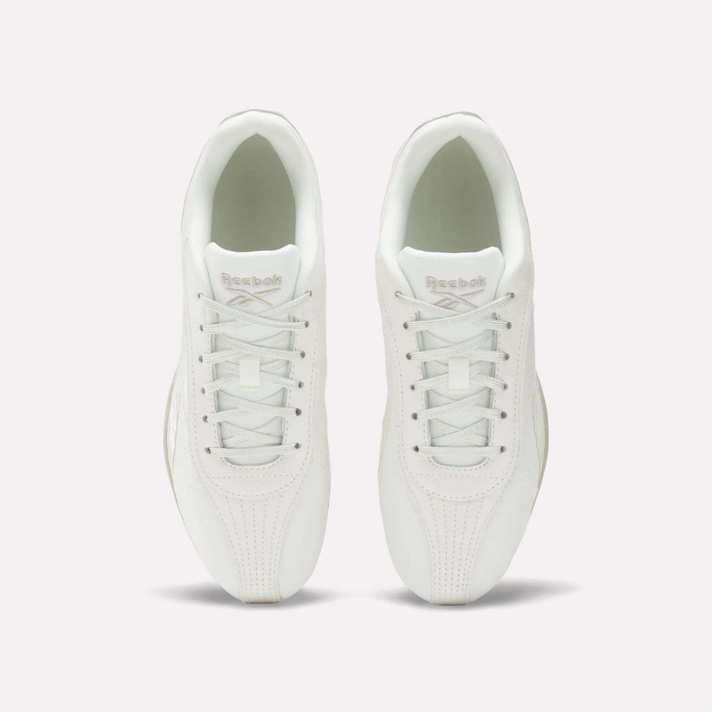 Top view of Women's Ultra Lo Shoes by Reebok in white, featuring white laces and Reebok branding on the tongues. The low-profile, minimalist shoes are placed side by side on a plain white background.