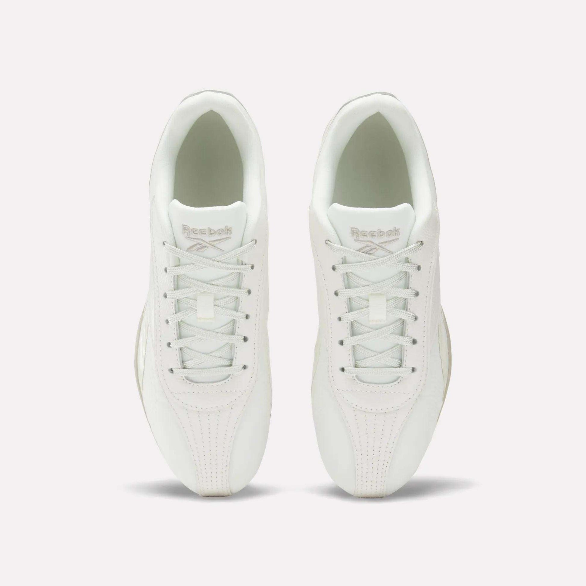 Top view of Women's Ultra Lo Shoes by Reebok in white, featuring white laces and Reebok branding on the tongues. The low-profile, minimalist shoes are placed side by side on a plain white background.