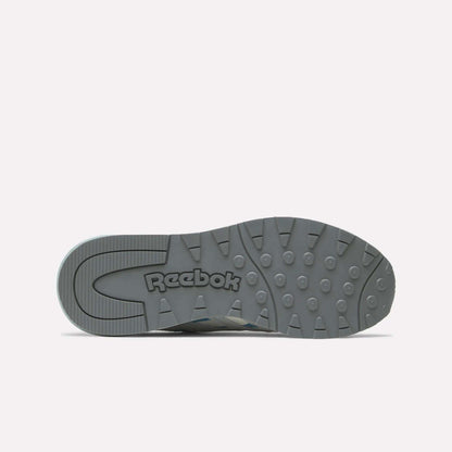 The sole of a gray Reebok Women's Classic Nylon 89 Shoe is shown from the bottom, featuring the Reebok logo and textured tread with circular grips on a white background—ideal for fans of retro style women’s running shoes.