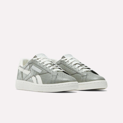 The Reebok Women's Club C Grounds UK Shoes feature a gray leather upper with white soles, laces, and side detailing, shown on a plain white background.