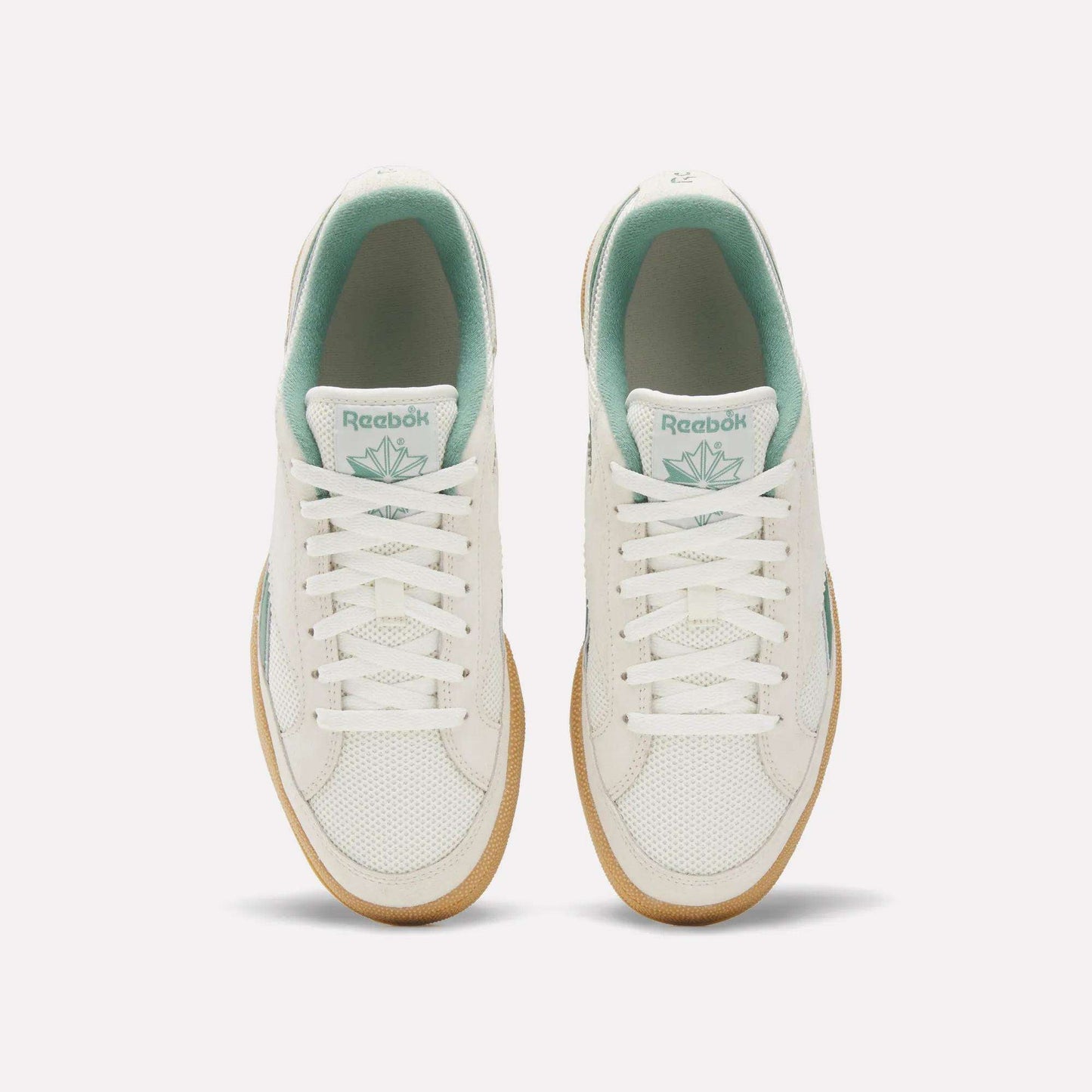 Top view of Reebok Club C Grounds 70 Shoes in white with mint green accents, white laces, and gum soles. Inspired by the '70s, these sneakers feature premium suede details and are displayed side by side on a plain white background.