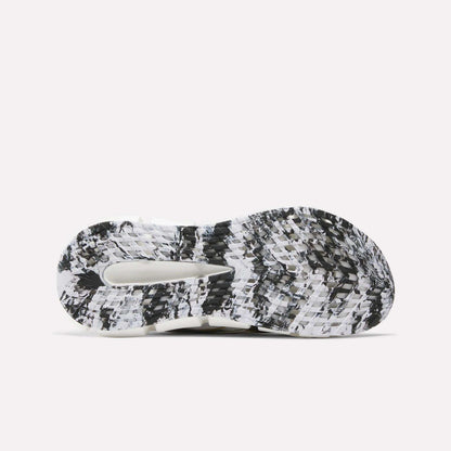 The image displays the sole of Reebok FloatZig 2 Running Shoes, featuring a black, white, and grey marbled pattern with textured treads, a central cutout for enhanced grip, and Superfloat+ cushioning.