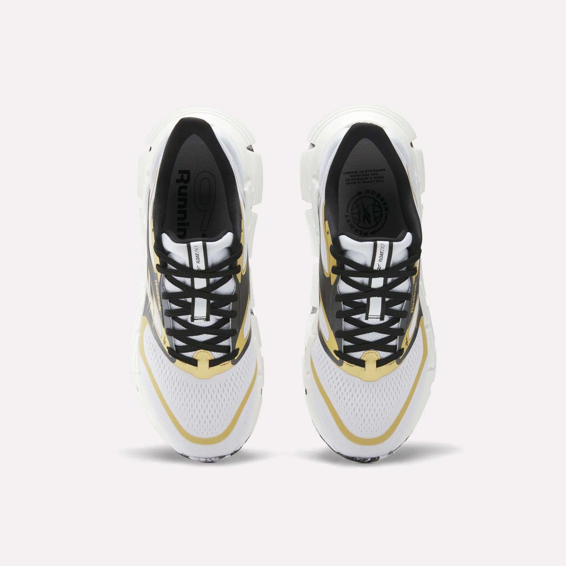 Top view of a pair of Reebok FloatZig 2 Running Shoes in white with black and yellow accents, Superfloat+ cushioning for energy return, black laces, and "Running" on the insole, placed side by side on a light background.