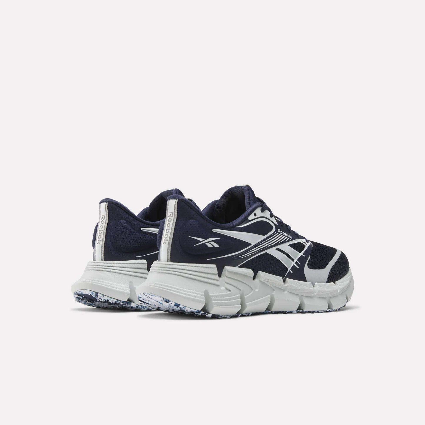 A pair of Reebok FloatZig 2 Running Shoes in navy blue and white, featuring thick textured soles and Superfloat+ cushioning, shown from the back and side on a plain white background.