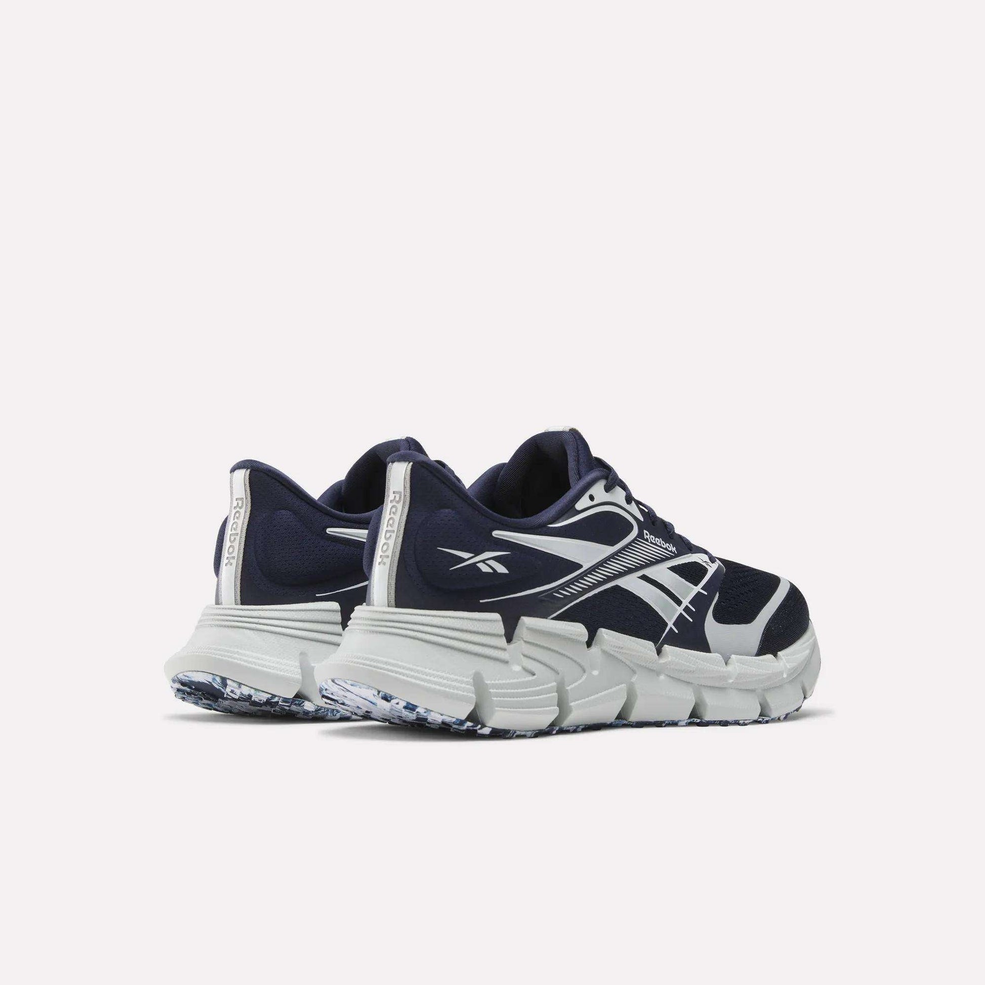 A pair of Reebok FloatZig 2 Running Shoes in navy blue and white, featuring thick textured soles and Superfloat+ cushioning, shown from the back and side on a plain white background.