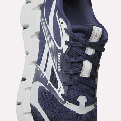 Close-up of Reebok FloatZig 2 Running Shoes in navy blue with white accents, showcasing a chunky white Superfloat+ cushioned sole and visible FLOATZIG and Reebok branding on the tongue and side.