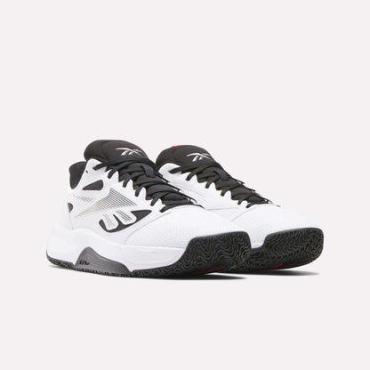 A pair of Reebok Engine LT Shoes in white with black accents and textured black soles, shown on a plain light background. These performance sneakers feature mesh uppers, the iconic logo, and a low-cut design for agility.