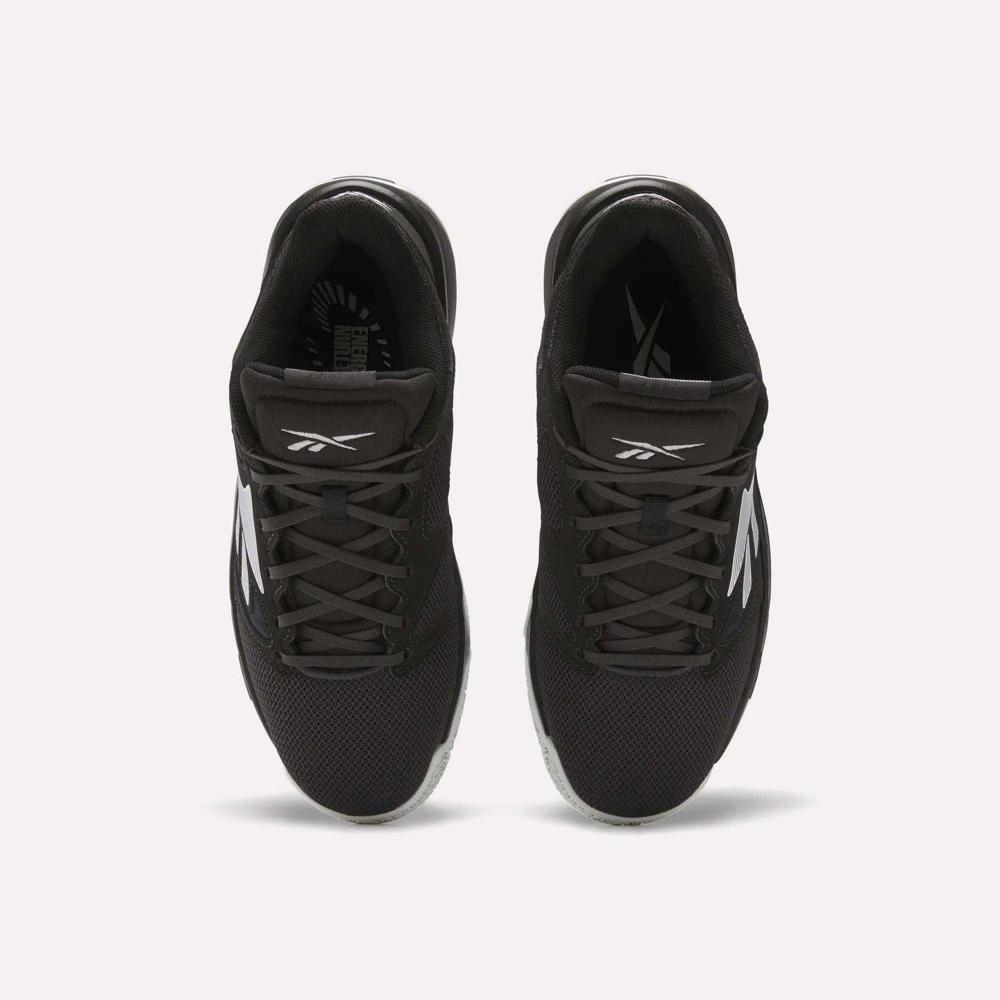 Top view of a pair of Reebok Engine LT Shoes in black with white logos and accents, featuring mesh uppers and black laces, placed side by side on a white background.