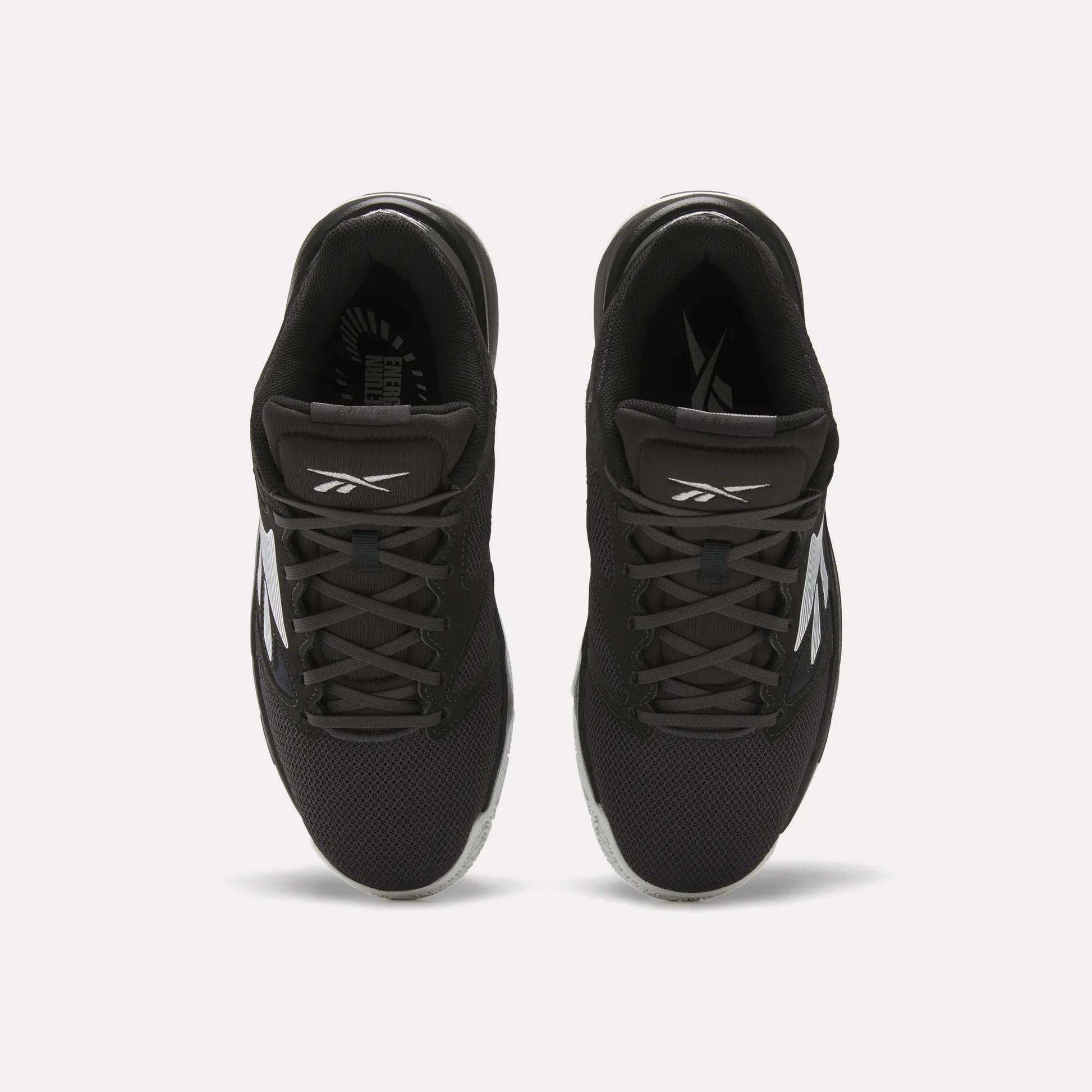 Top view of a pair of Reebok Engine LT Shoes in black with white logos and accents, featuring mesh uppers and black laces, placed side by side on a white background.