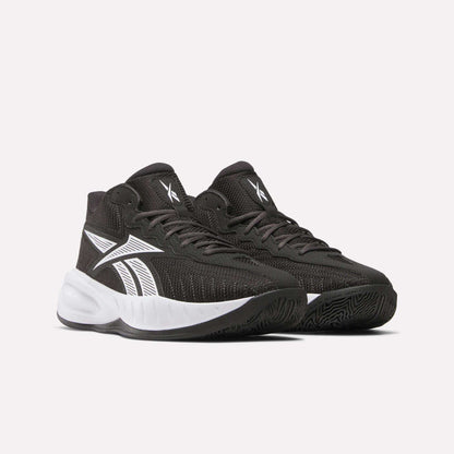 Reebok Press Basketball Shoes in black with white accents and soles, featuring a bold white side logo and EVA cushioning for comfort, are displayed against a plain light background.