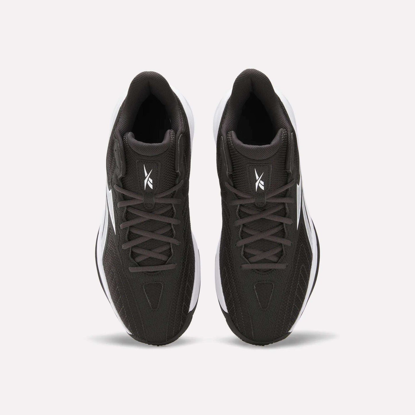 Top view of Reebok Press Basketball Shoes in black with white soles and logo on the tongue, shown side by side on a white background. These shoes offer responsive comfort with EVA cushioning.