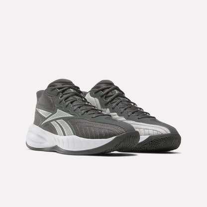 The Reebok Press Basketball Shoes are gray athletic sneakers with white accents and thick white soles. Inspired by basketball heritage, they feature a mesh texture, lace-up design, and comfortable EVA cushioning against a plain background.