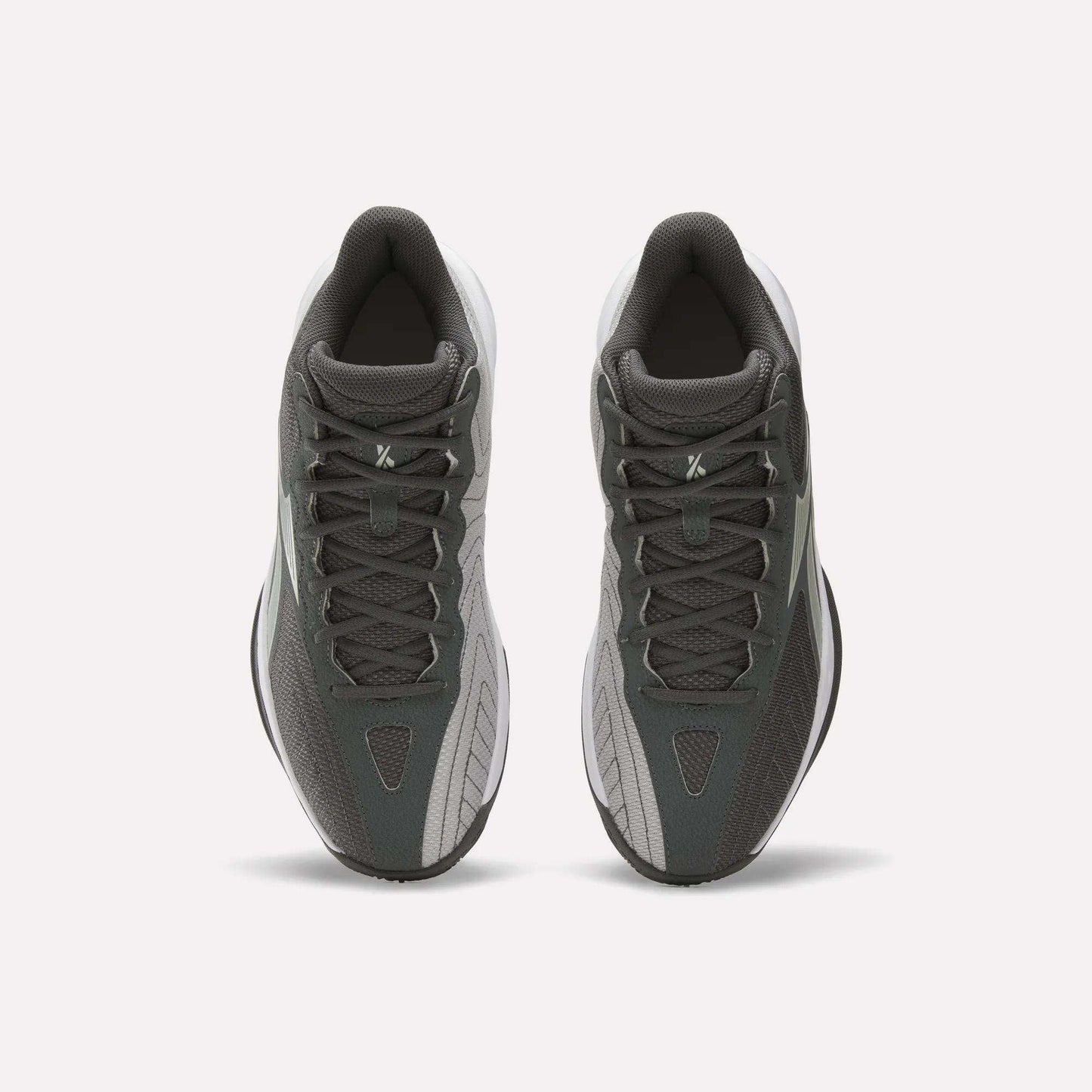 A pair of Reebok Press Basketball Shoes in dark gray and light gray are shown from above, highlighting their laces and classic basketball style against a plain white background.