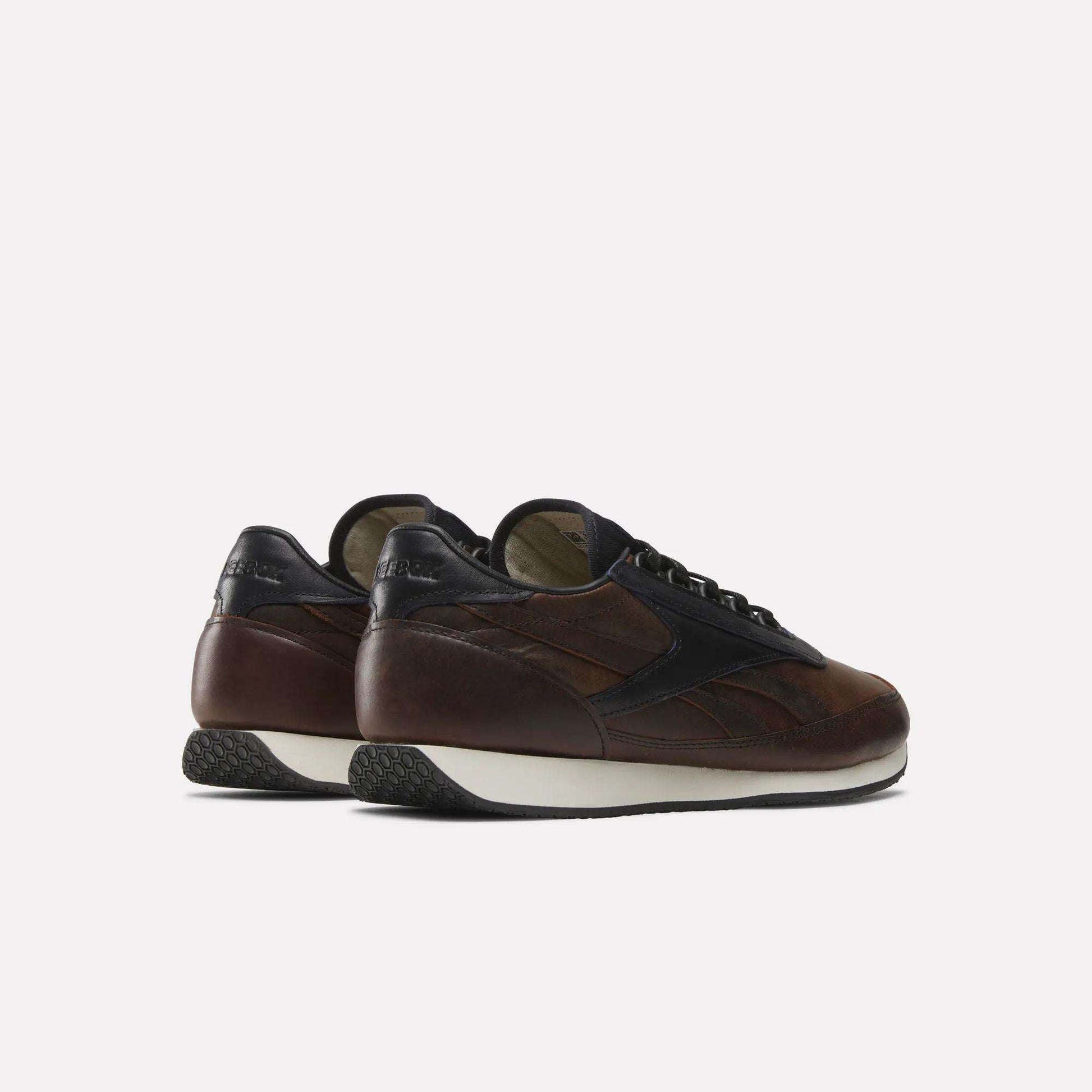 The Reebok Camargue x C.F. Stead Shoes are brown and black full-grain leather sneakers with white soles, shown from the back and side against a plain light background.
