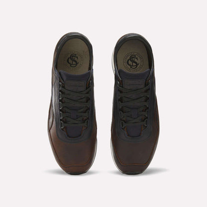 The Reebok Camargue x C.F. Stead Shoes feature brown full-grain leather, black laces, and dark mesh accents, shown from above on a plain light background.