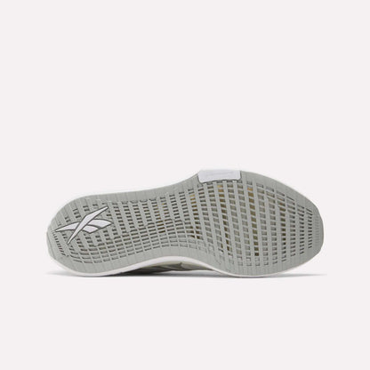 The image features the bottom view of a light grey Reebok Men's FloatZig Tread Running Shoe sole with a gridded tread and Reebok logo near the heel, perfect for treadmill workouts. The background is plain white.