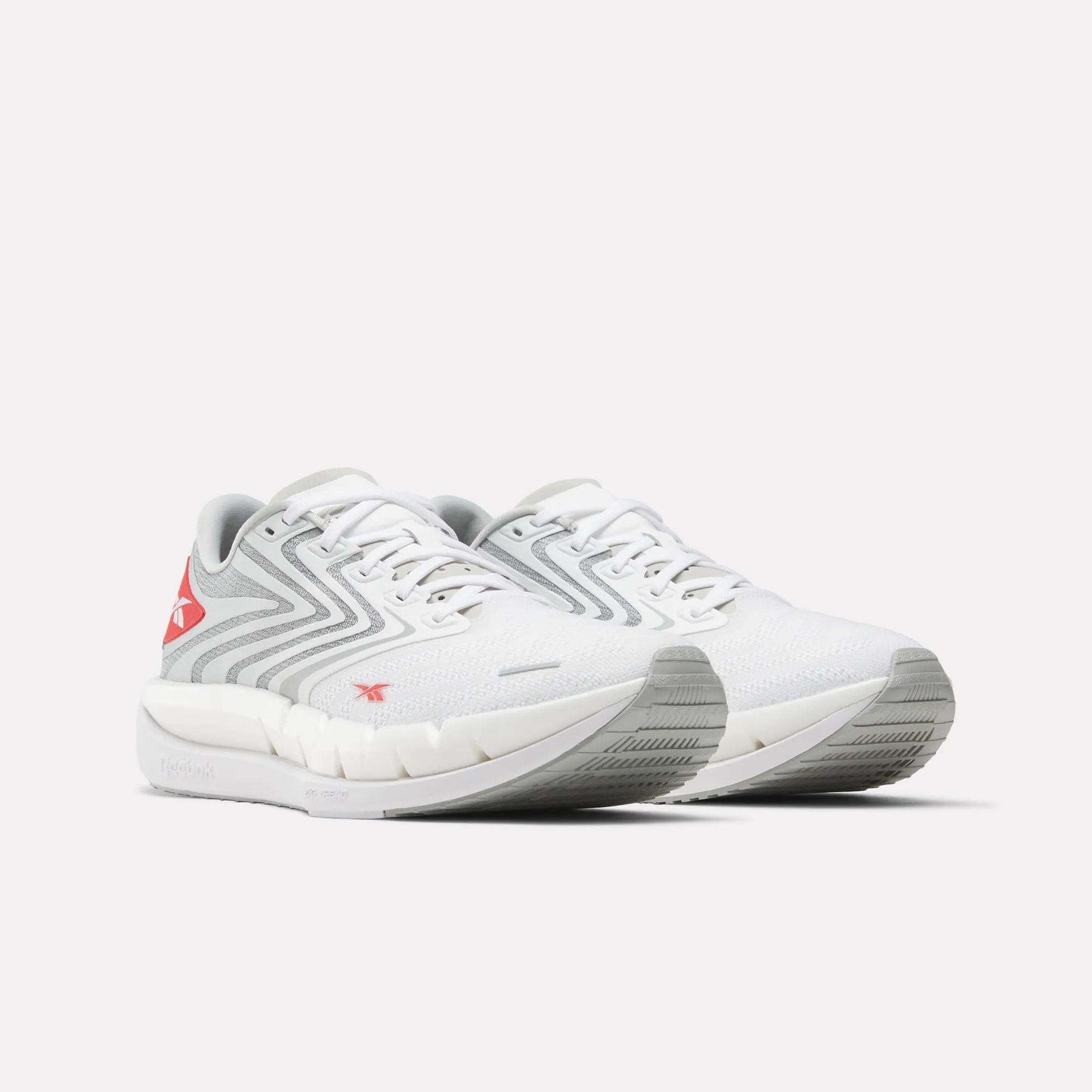 The Reebok Men's FloatZig Tread Running Shoes in white with light gray and red accents feature a zigzag side design, cushioned midsole, and textured sole—perfect for treadmill workouts—shown on a plain white background.