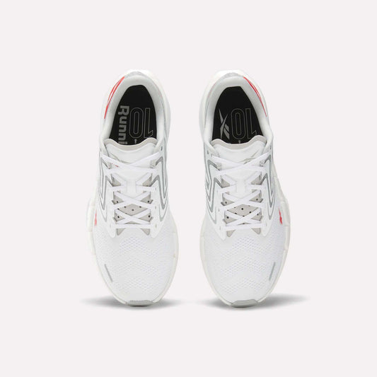 A pair of Men's FloatZig Tread Running Shoes by Reebok in white with gray and red accents, viewed from above, show the tops, laces, cushioned midsole, and "Running" text on black insoles—ideal for treadmill workouts.