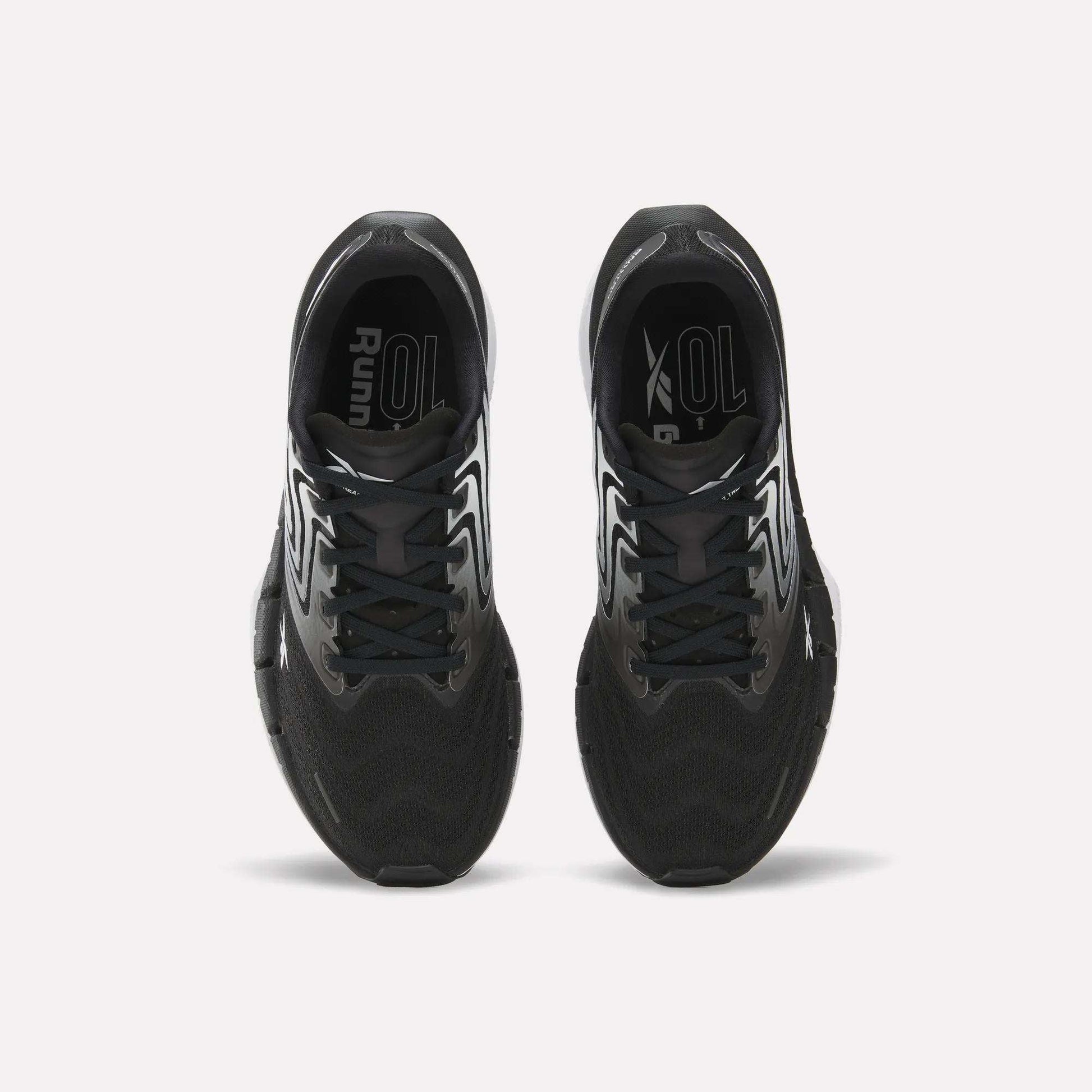 Top view of Reebok Women's FloatZig Tread Running Shoes with white accents on a white background. Features breathable mesh uppers and branded insoles, ideal for treadmill workouts.