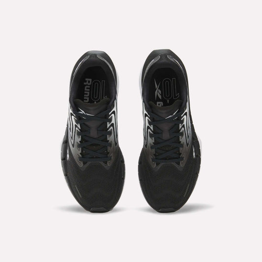 Top view of Reebok Women's FloatZig Tread Running Shoes with white accents on a white background. Features breathable mesh uppers and branded insoles, ideal for treadmill workouts.
