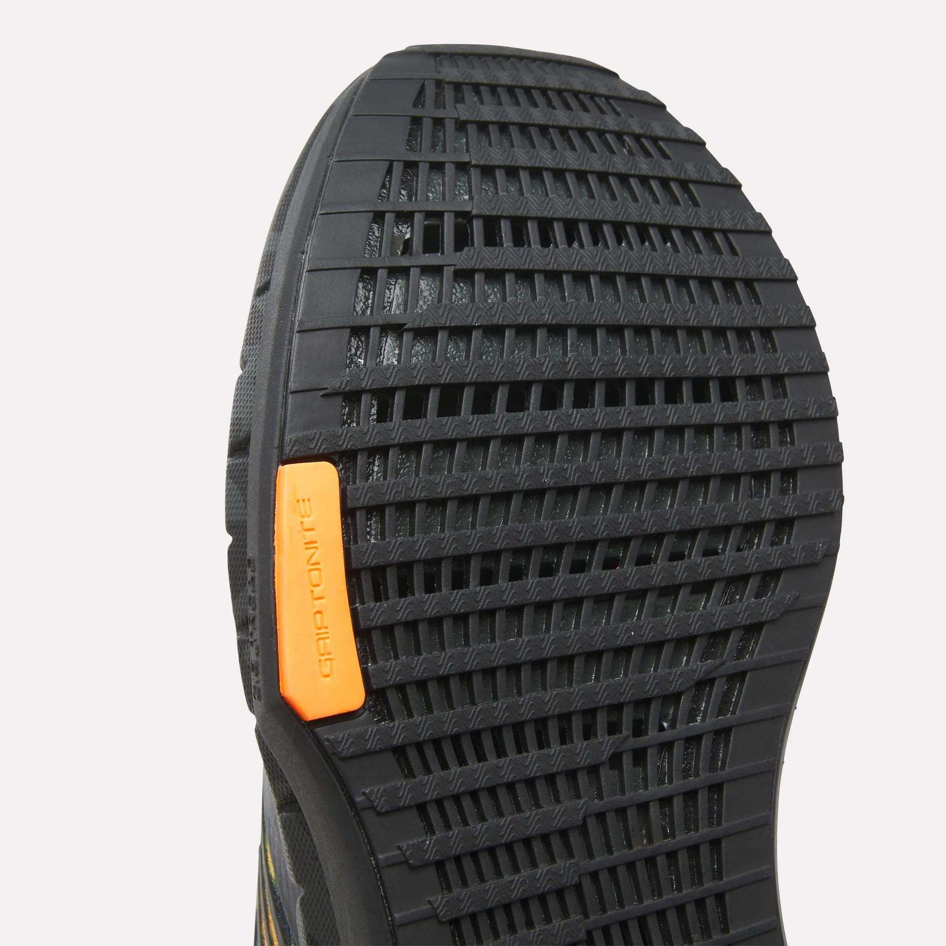 Close-up of the black sole on Reebok Women's FloatZig Tread Running Shoes, highlighting a textured grid pattern and orange GRIPTONITE label—delivering excellent traction for treadmill runs and supporting breathable mesh uppers.