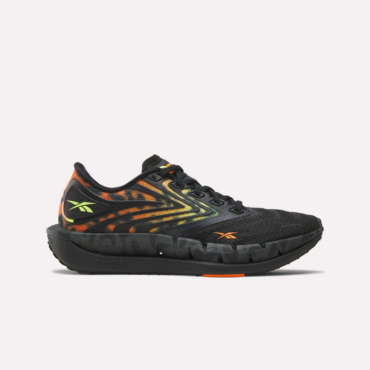 The Reebok Women's FloatZig Tread Running Shoes feature a breathable black mesh upper, vibrant orange and yellow flame patterns, neon yellow logo, plus orange accents—ideal for treadmill workouts.