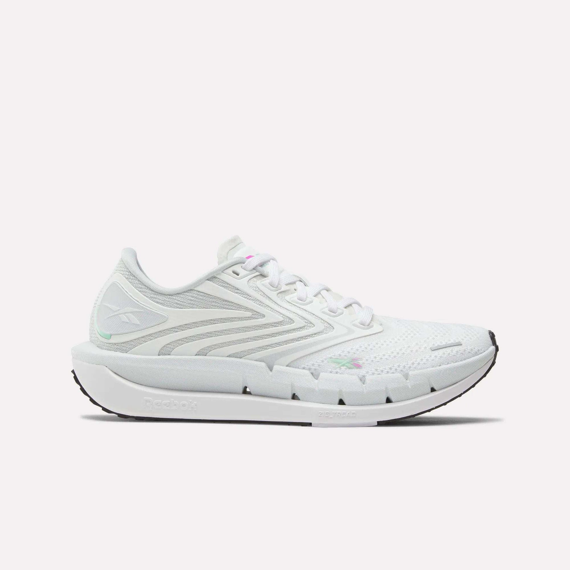The Reebok Women's FloatZig Tread Running Shoes feature gray accents, a breathable mesh upper, lace-up closure, sculpted sole, and logo on the side and heel. Shown in side view, they're ideal as stylish treadmill running shoes.