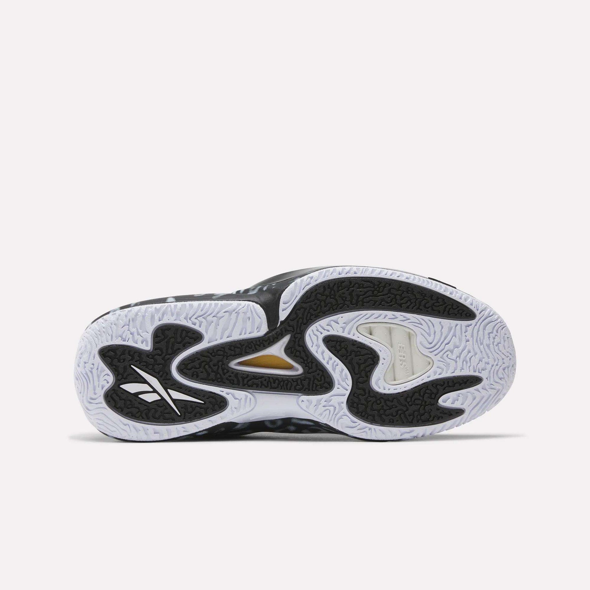 The image shows the sole of the Reebok Engine A 26 Basketball Shoes, with a wavy black and white pattern, textured grip, and a gold accent near the midfoot. The Reebok logo highlights their lightweight support for peak performance.