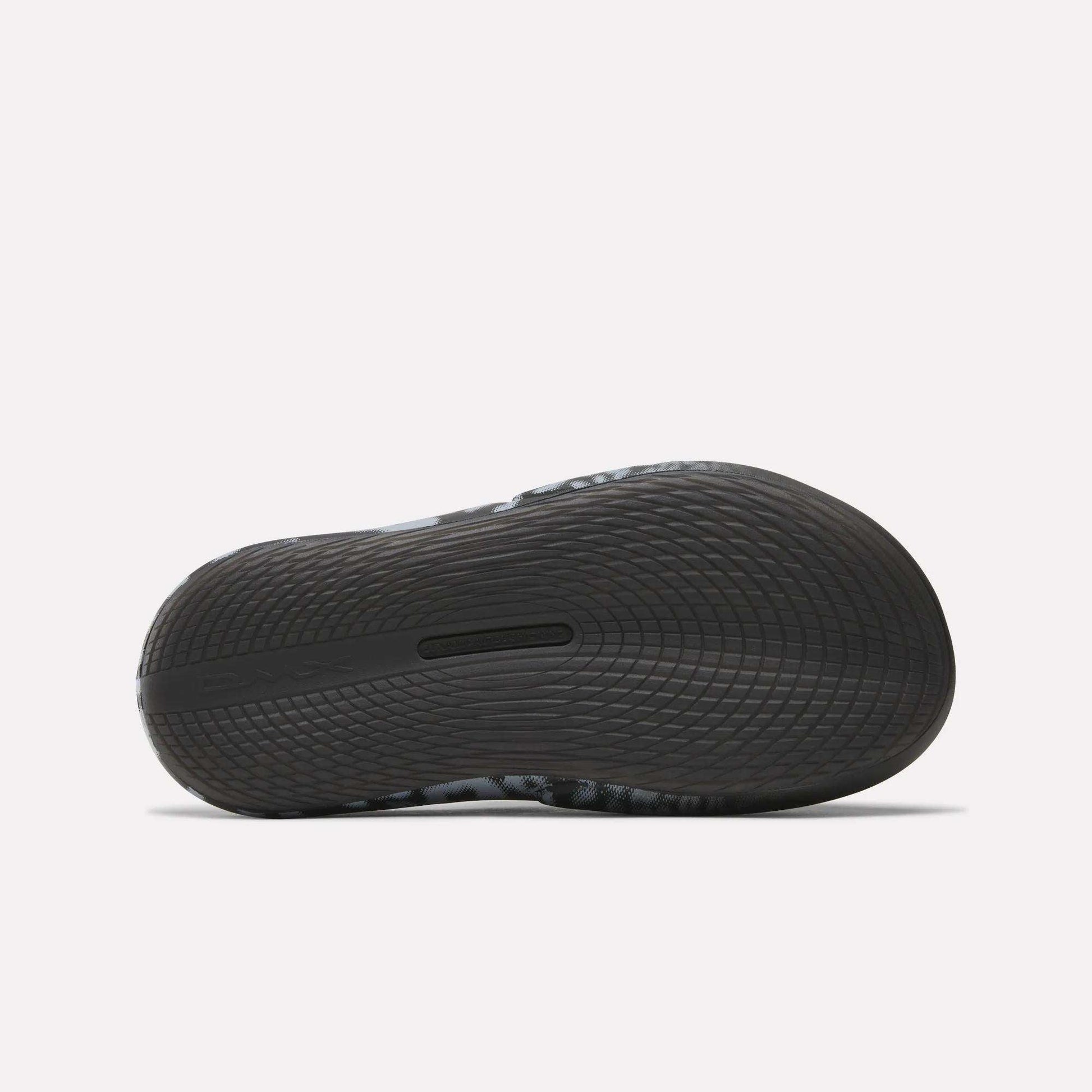 Close-up of the sole on Reebok DMX Recovery Mules, a black athletic shoe with DMX cushioning and wavy tread for excellent grip—perfect as recovery footwear after intense workouts.