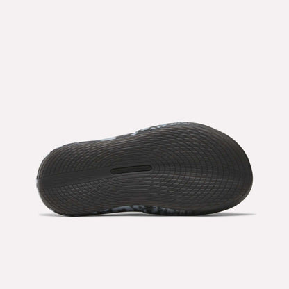Close-up of the sole on Reebok DMX Recovery Mules, a black athletic shoe with DMX cushioning and wavy tread for excellent grip—perfect as recovery footwear after intense workouts.