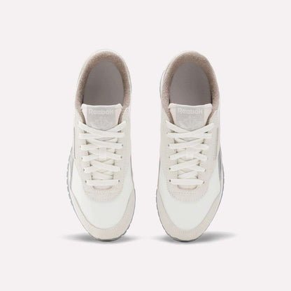 The Reebok Women's Classic AZ Shoes, in white with beige accents, are shown from above with visible laces, tongue, and Reebok branding. These vintage-style sneakers are placed side by side on a plain light background.