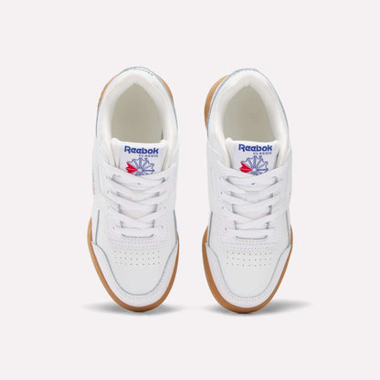 A pair of white Reebok Workout Plus Shoes for little kids, seen from above. They have gum soles, white laces, toe perforations, and display the blue and red Reebok logo on the tongue.