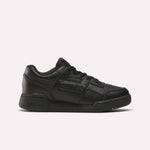 The Reebok Workout Plus Shoes for little kids feature a black low-top design, lace-up closure, and rubber sole, making them stylish and sporty. Displayed on a plain white background.