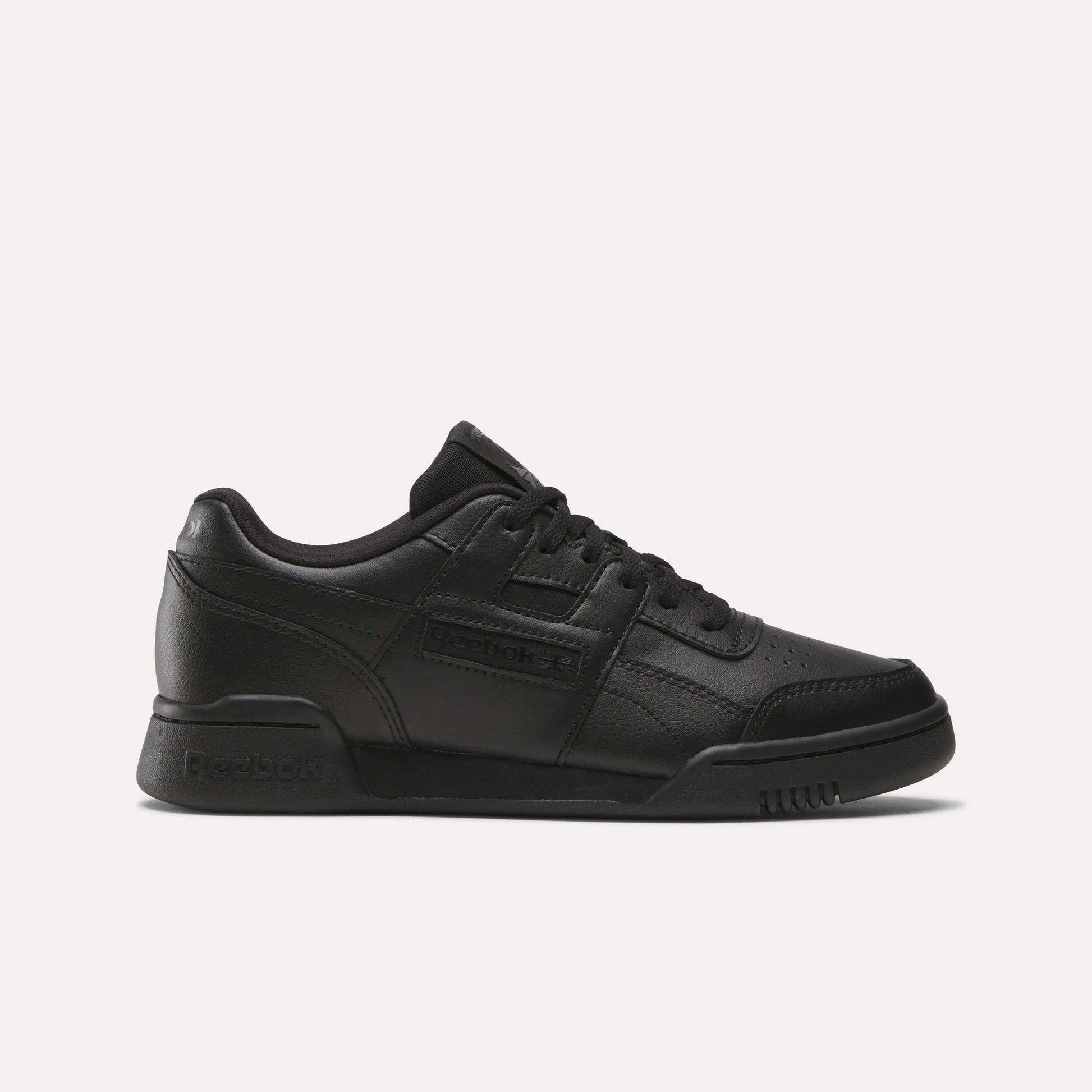 The Reebok Workout Plus Shoes - Big Kids feature a black low-top design with lace-up closure and classic Reebok branding, bringing retro style to juniors’ footwear, shown against a plain white background.